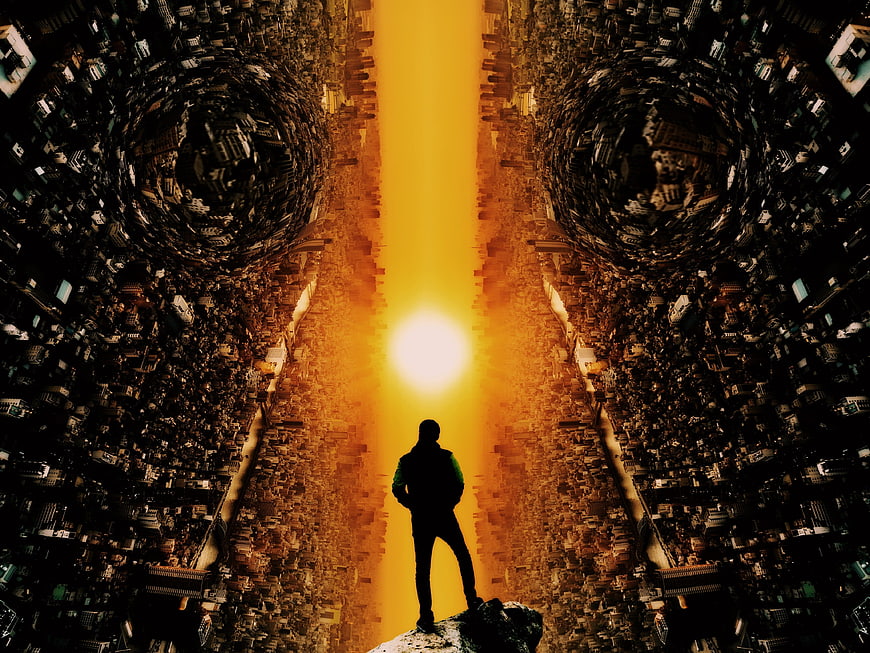 Silhouette of man standing on rock in futuristic cityscape with glowing sun