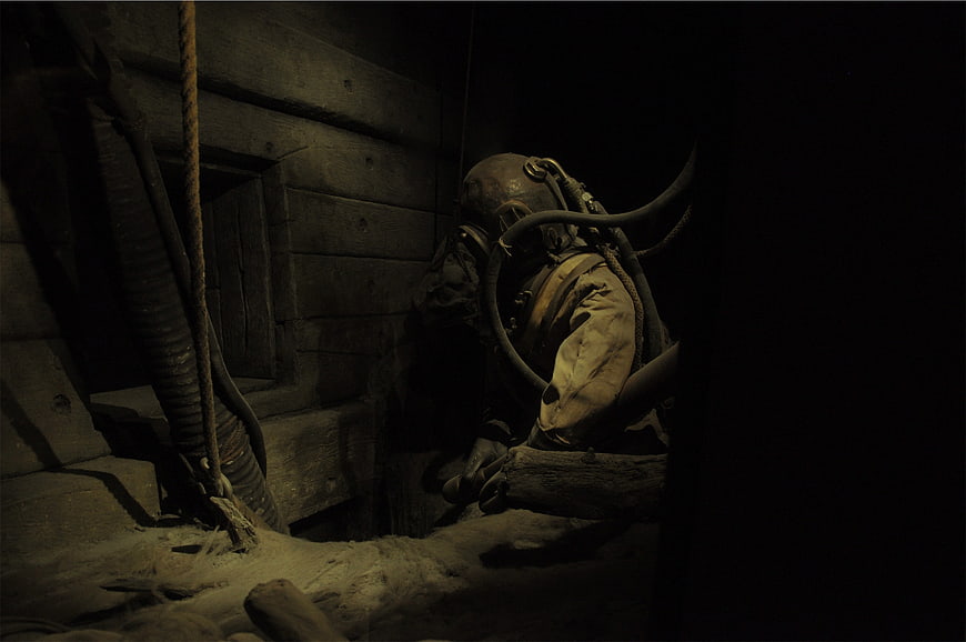 Historical miner in vintage protective suit and helmet
