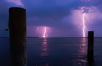 Dramatic Lightning Storm Over Ocean with Wooden Pilings