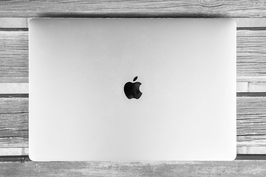 Top view of closed silver laptop on wooden background