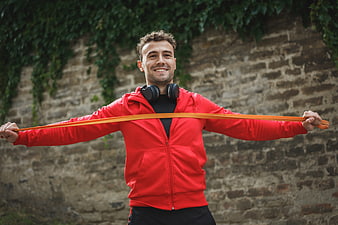 Happy Man Exercising with Resistance Band Outdoors