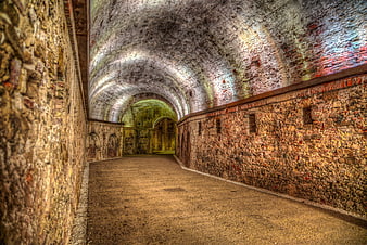 Historic Stone Vaulted Corridor With Arched Ceiling And Textured Walls