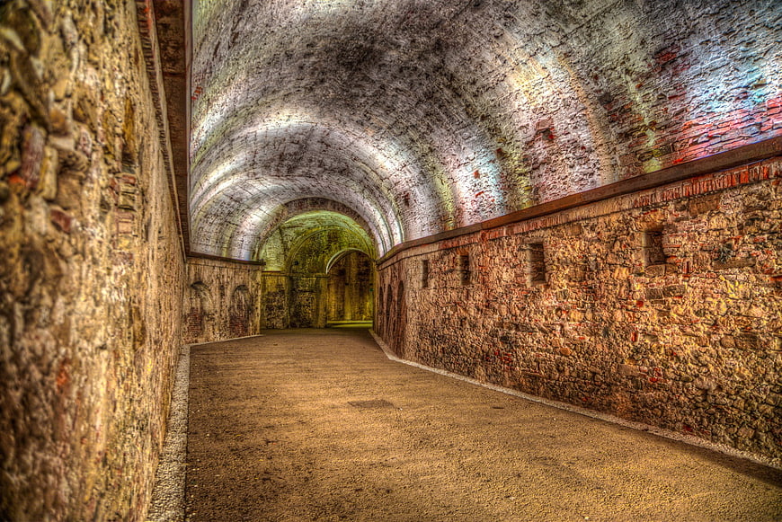 Historic Stone Vaulted Corridor With Arched Ceiling And Textured Walls