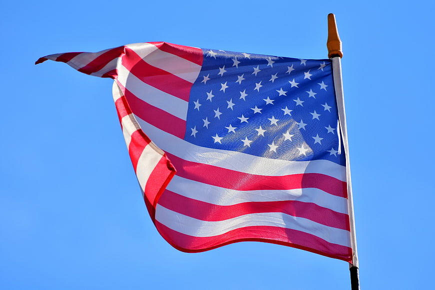 American Flag Fluttering In Clear Blue Sky