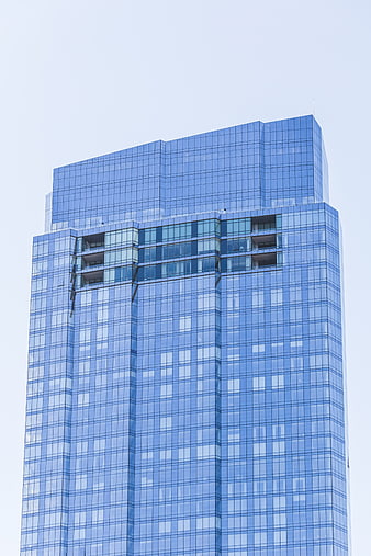 Modern Blue Glass Skyscraper Against Clear Sky