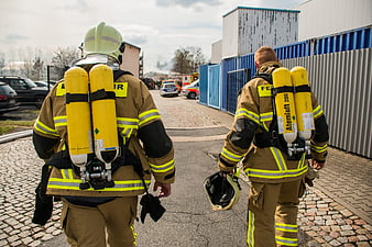 Two Firefighters Walking Away With Yellow Air Tanks