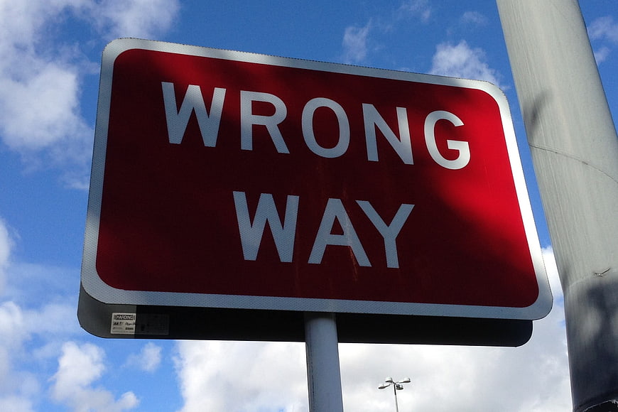 Red Wrong Way Traffic Sign Against Blue Sky