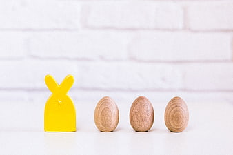 Yellow Wooden Bunny and Eggs on White Background