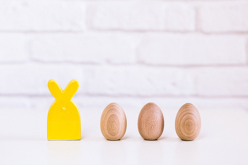Yellow Wooden Bunny and Eggs on White Background