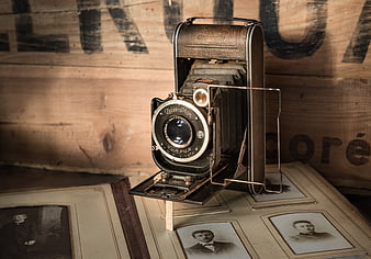 Vintage folding camera on old photo album