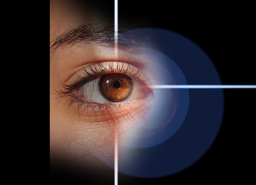 Close-up of human eye with laser crosshair targeting