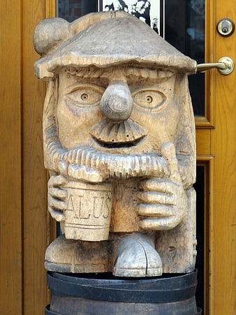 Hand-carved wooden gnome sculpture holding a beer mug
