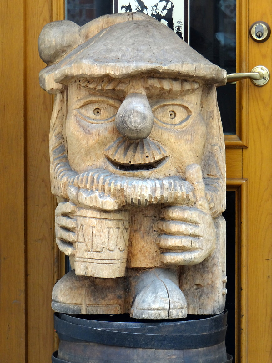 Hand-carved wooden gnome sculpture holding a beer mug