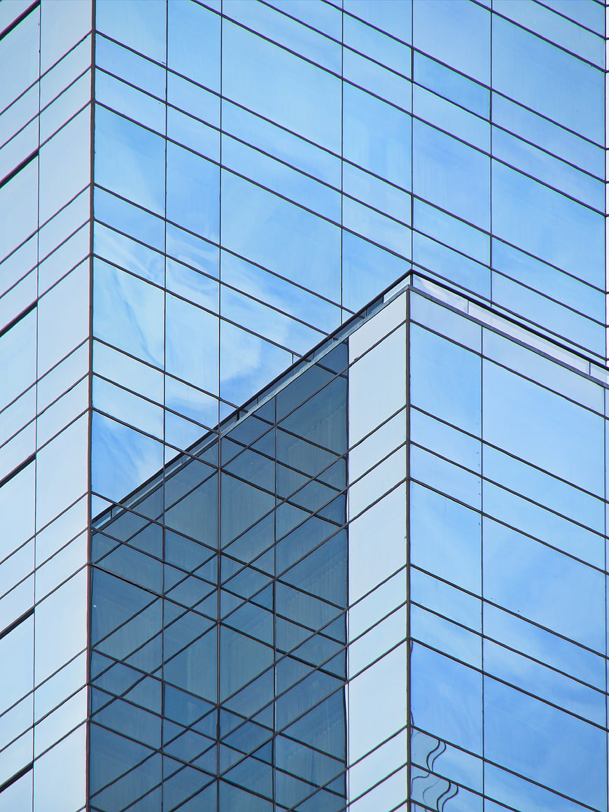 Modern Glass Skyscraper Facade with Blue Sky Reflection