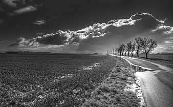 Dramatic black and white landscape with road and clouds