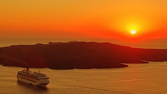Cruise Ship Sailing Past Island Silhouette at Vibrant Sunset