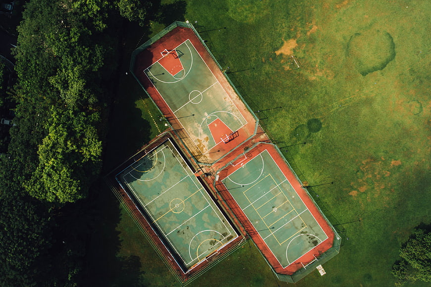 Aerial view of three outdoor basketball courts in a park