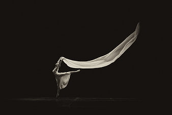 Ballerina with flowing fabric in dramatic black and white dance pose