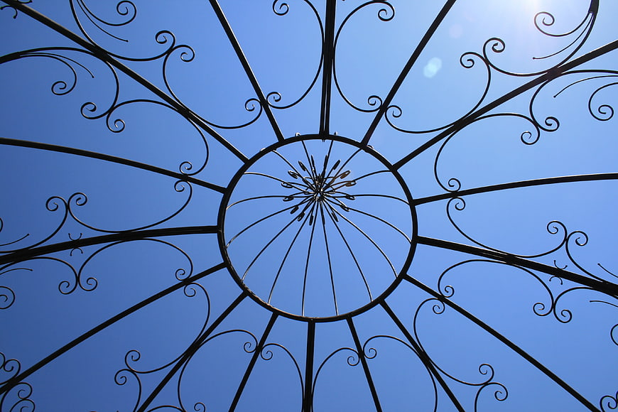 Ornate Wrought Iron Spiral Ceiling Against Blue Sky