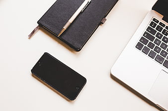 Minimalist workspace with laptop, smartphone, and notebook