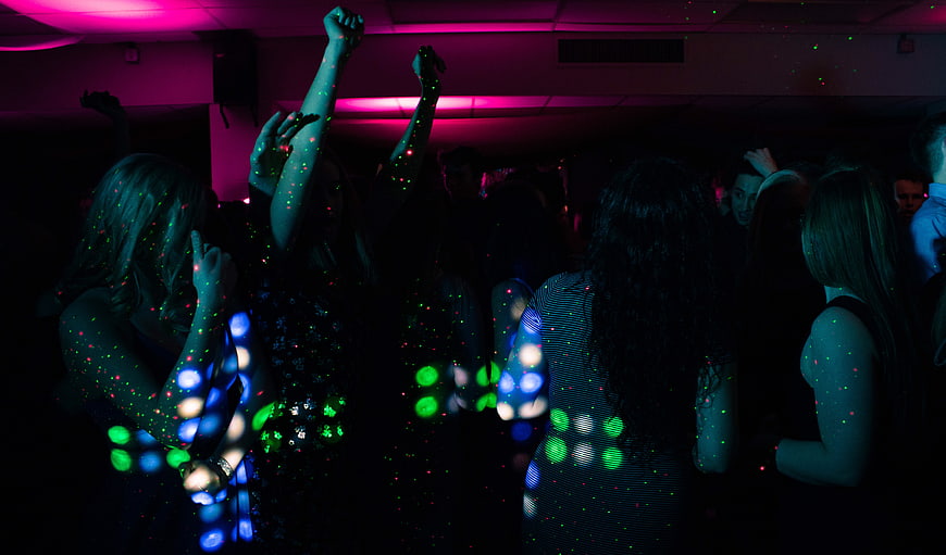 Silhouettes of People Dancing in a Dark Club with Disco Lights