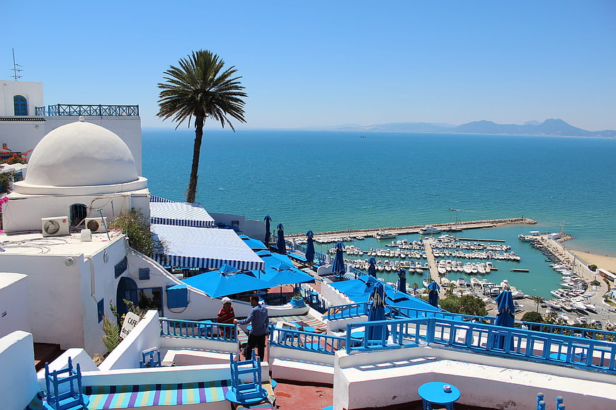 White and blue Mediterranean architecture overlooking a marina and sea