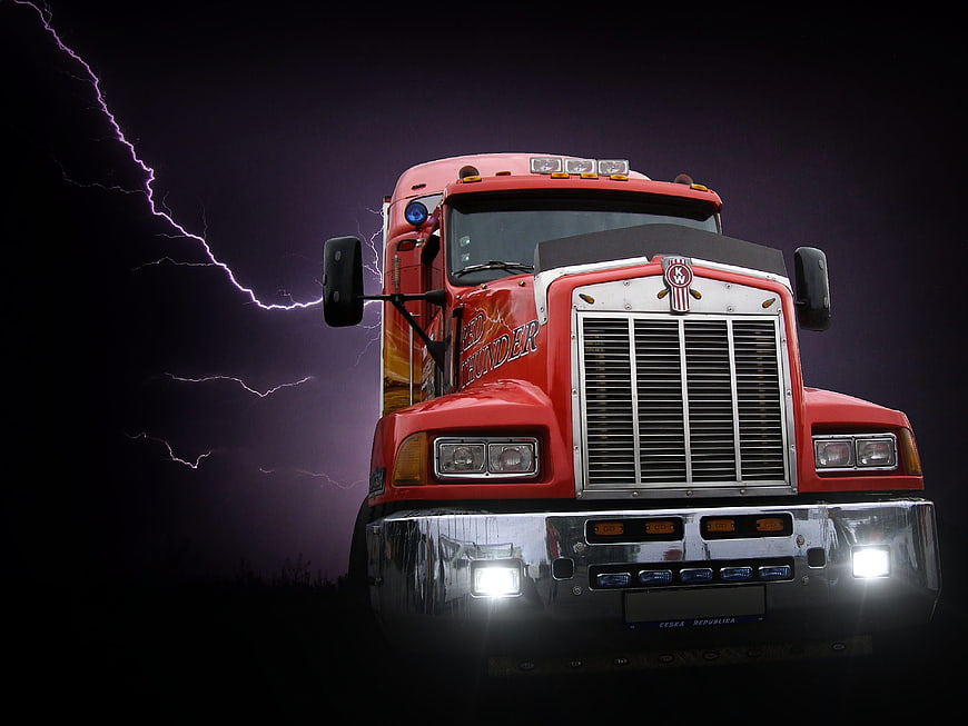 Red Semi Truck Front View With Dramatic Lightning Storm Background