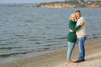 Happy Senior Couple Hugging on Sandy Beach Shore