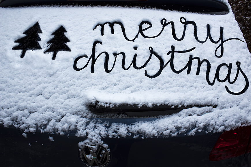 Merry Christmas Handwritten in Snow on Car Trunk