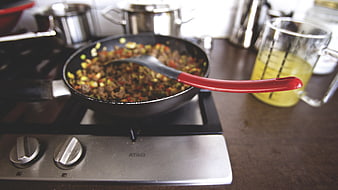Cooking Stir-Fry in Pan on Stove with Red Ladle