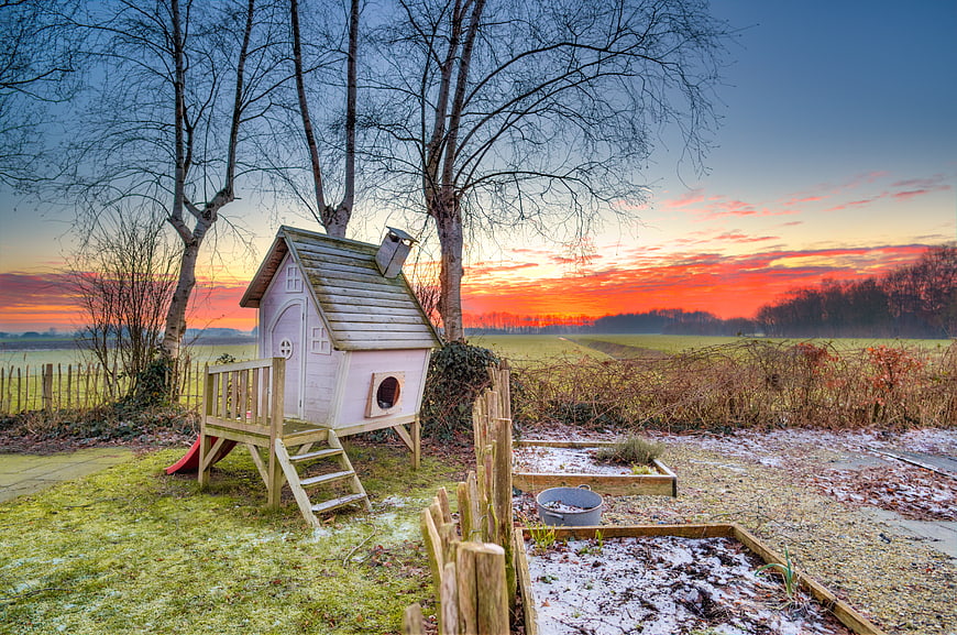 Child's Playhouse in Frosty Garden at Sunset
