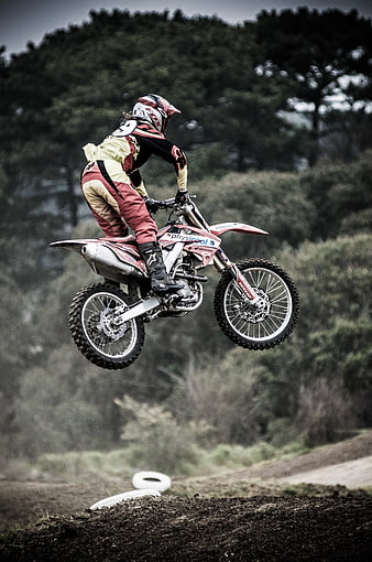 Motocross Rider Jumping Dirt Bike on Forest Track