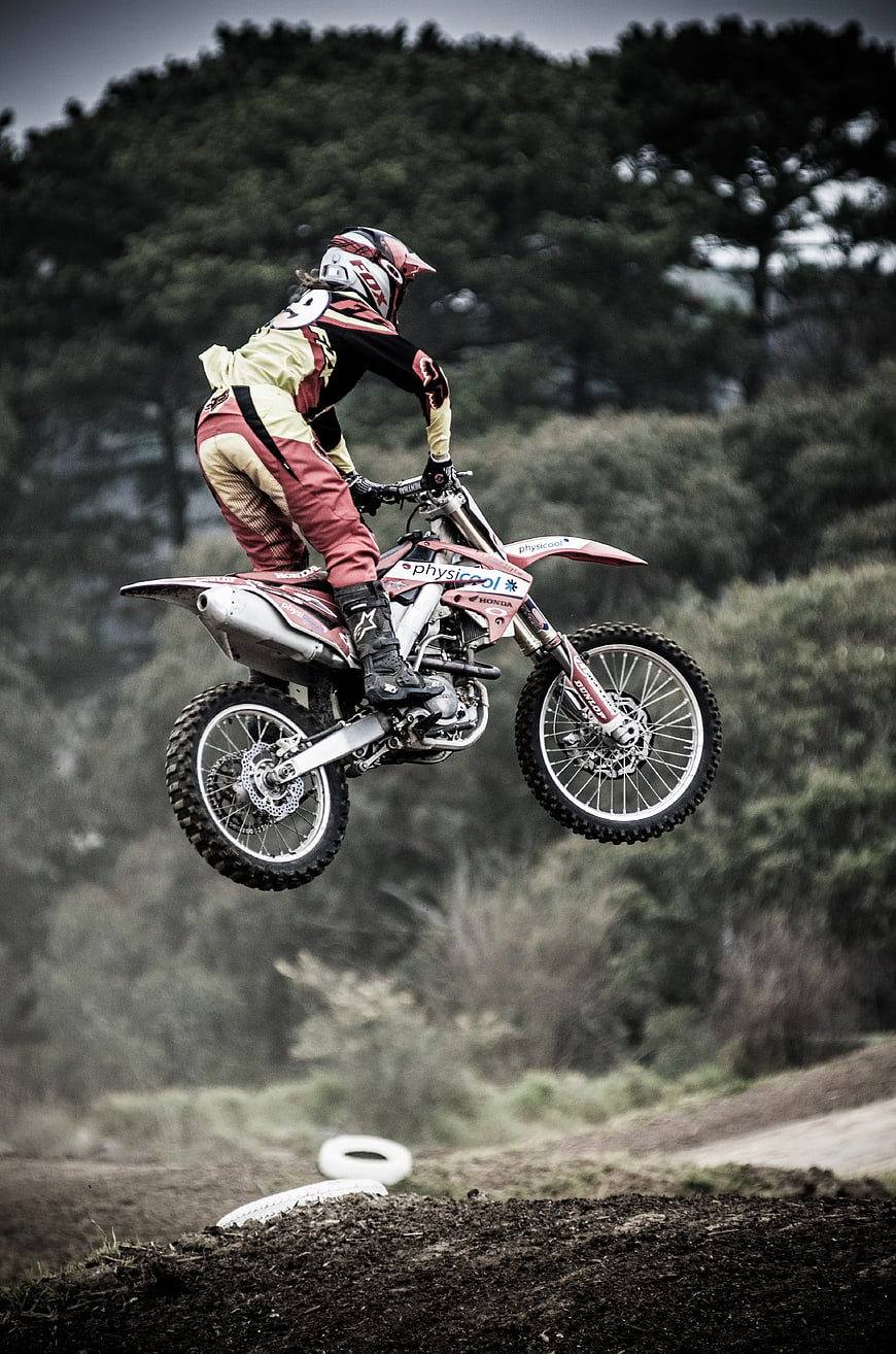 Motocross Rider Jumping Dirt Bike on Forest Track