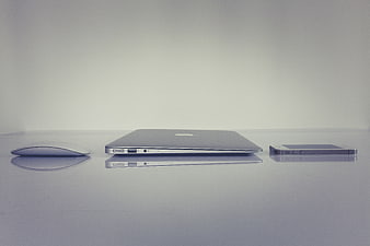Minimalist Apple MacBook, Mouse, and iPhone on White Surface