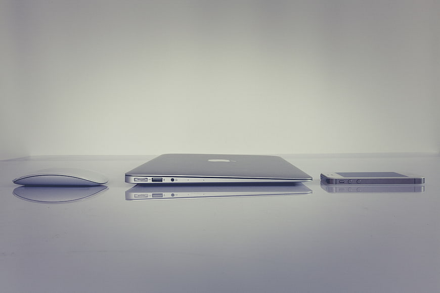 Minimalist Apple MacBook, Mouse, and iPhone on White Surface