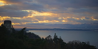 Panoramic sunset over lake with distant snow-capped mountains