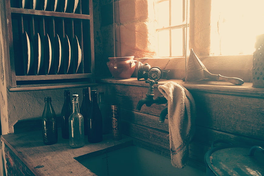 Vintage rustic kitchen interior with wooden shelves and sunlight