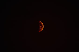Partial Lunar Eclipse with Reddish Moon in Dark Night Sky