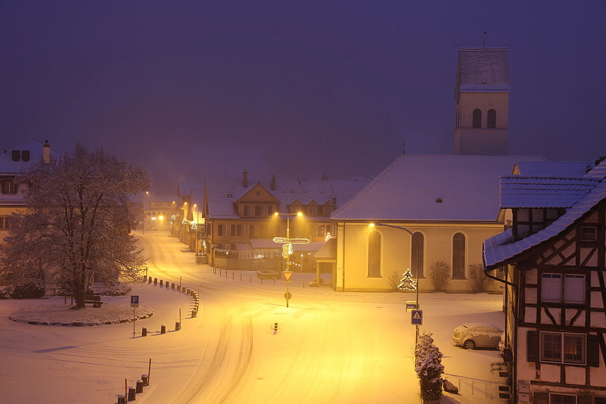 Snowy European Village Street at Night with Church