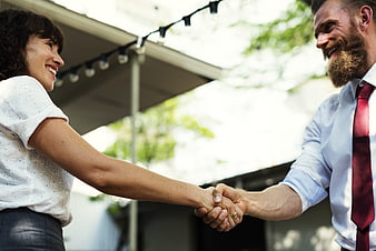 Smiling business people shaking hands outdoors