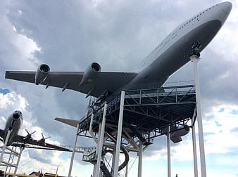 Low angle view of large white airplane on display stand