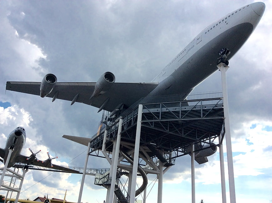 Low angle view of large white airplane on display stand