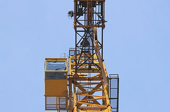 Yellow Construction Crane Tower Against Blue Sky