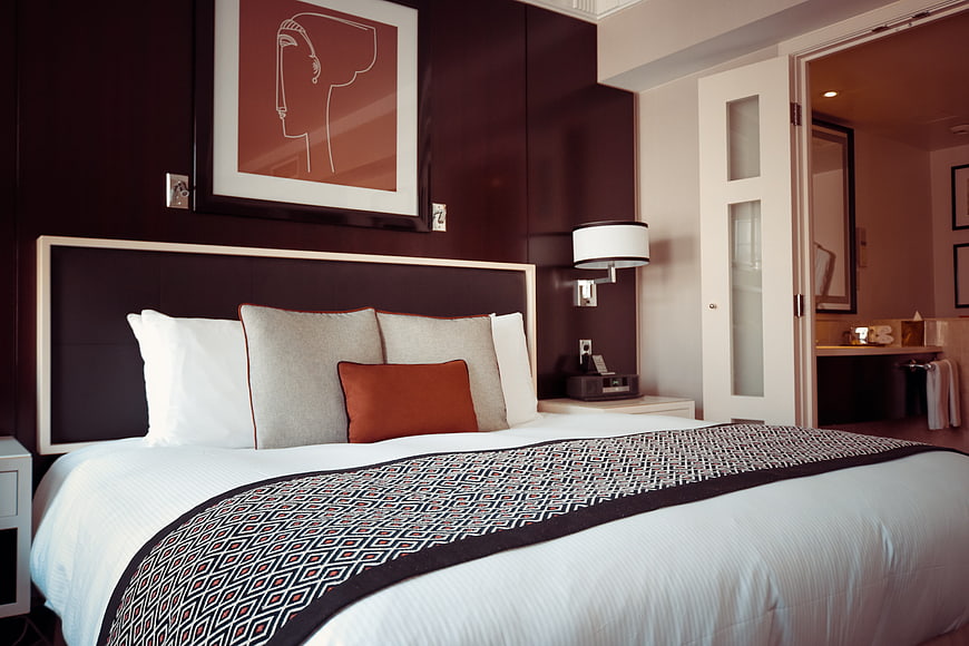 Modern Hotel Bedroom Interior with Dark Wood and Art