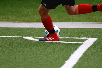 Close-up of soccer player's foot and ball on artificial turf corner