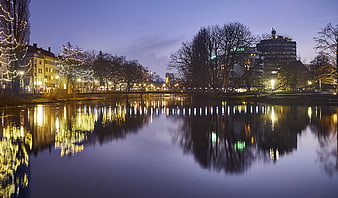 Cityscape at Dusk with River Reflections and Holiday Lights