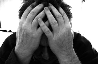 Man holding head in hands expressing stress and despair