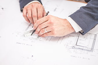 Architect hands drawing on blueprint with ruler and pencil