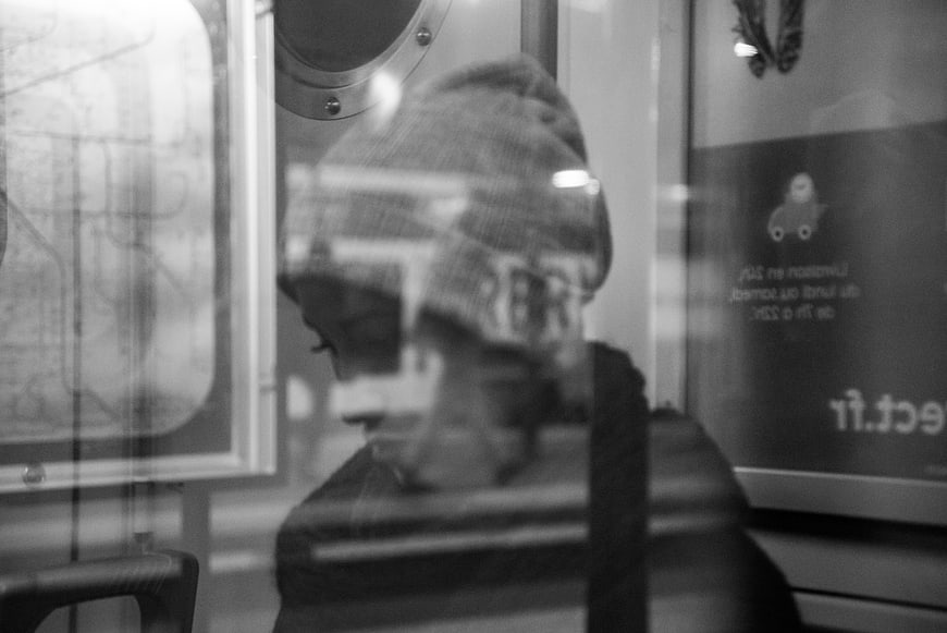 Woman in Beanie Reflected in Metro Window