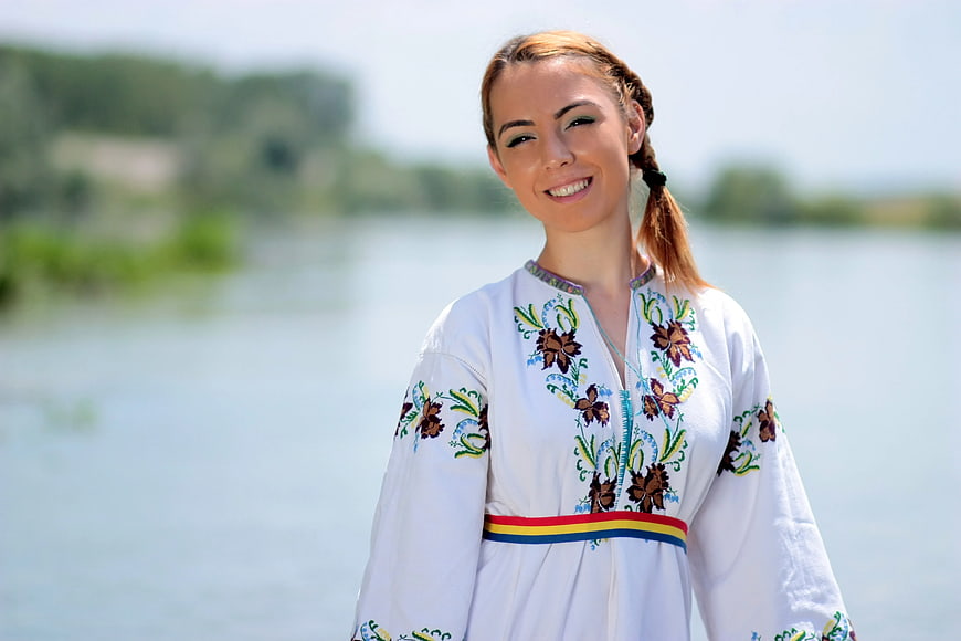 Woman in Traditional Embroidered Dress by Lake